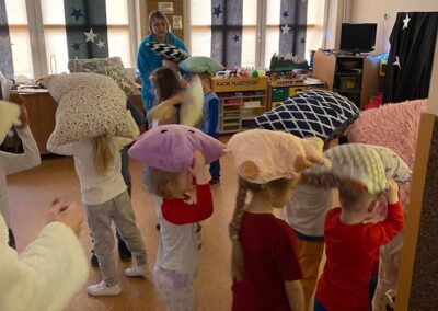 Dzieci z grupy niedźwiadków tańczą z poduszkami.