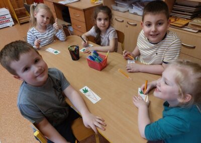 Dzieci kolorują ilustracje marchewek.