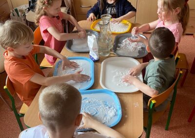Dzieci badają właściwości wody oraz mąki ziemniaczanej.