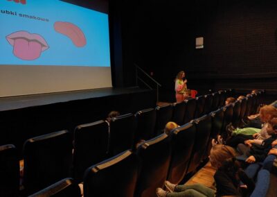 Animator wita dzieci w kinie.