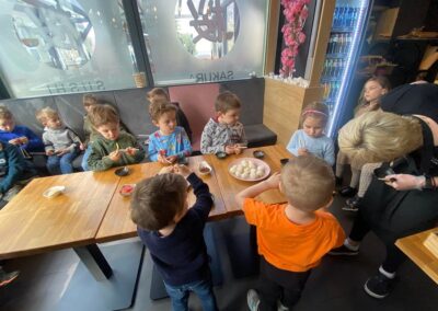 Dzieci próbują jeść przy pomocy pałeczek.