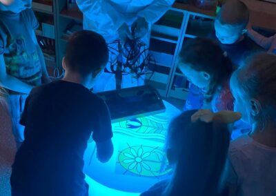 Dzieci układają kolorowe elementy na podświetlanym stoliku led.