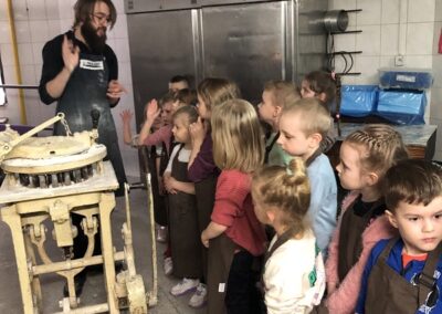Dzieci zwiedzają piekarnie i słuchają opowiadania o pracy piekarza.