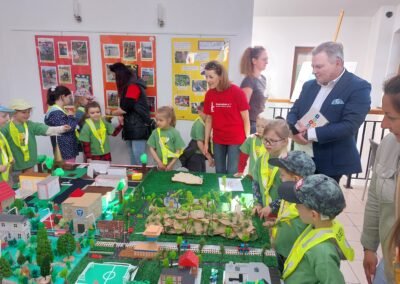Dzieci wraz z burmistrzem zwiedzają wystawę.
