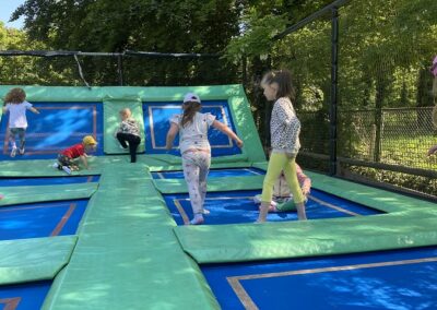 Dzieci skaczą na trampolinach.