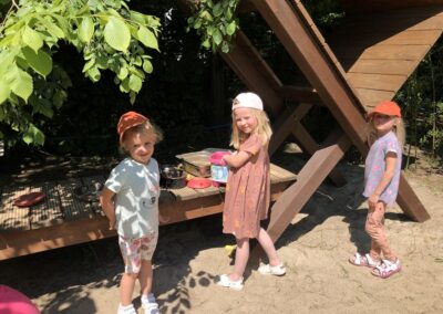 Dziewczynki bawią się w piasku.