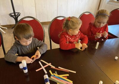 Dzieci robią łańcuch choinkowy z kolorowego papieru