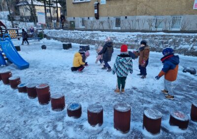 Dzieci bawią się na placu śniegiem.