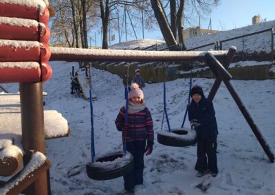 Dziewczynka i chłopiec bawią się na śniegu.