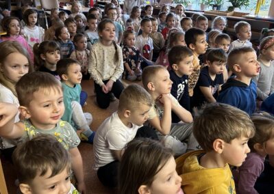 Dzieci siedzą na widowni w oczekiwaniu na występ.