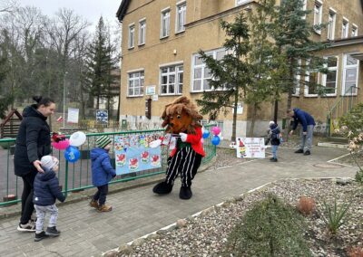 Gryfiński Jeżyk wita dzieci przed przedszkolem.