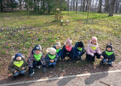 Dzieci szukają oznak wiosny w parku.