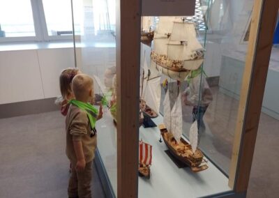Dzieci oglądają modele statków.