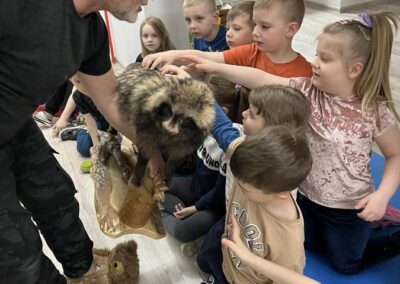 Dzieci głaskają futro leśnego psa.