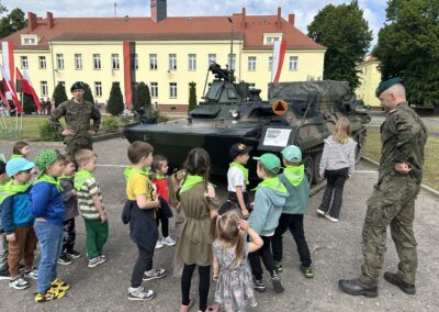 Dzieci z grupy żabek oglądają eksponaty wojskowe.