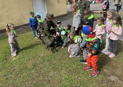 Dzieci z grupy żabek oglądają eksponaty wojskowe.